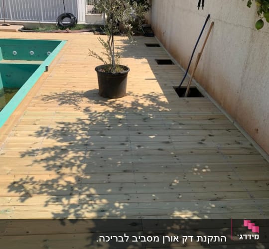 דק עץ עם עציץ וכלי עבודה בגינה